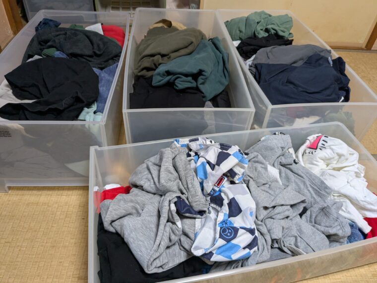 ぐちゃぐちゃに洋服がしまわれた収納ボックスの画像